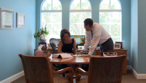 Drew Solnoki and Heather Byrd, attorneys at Byrd Law Firm, discussing case details in their Sarasota office.